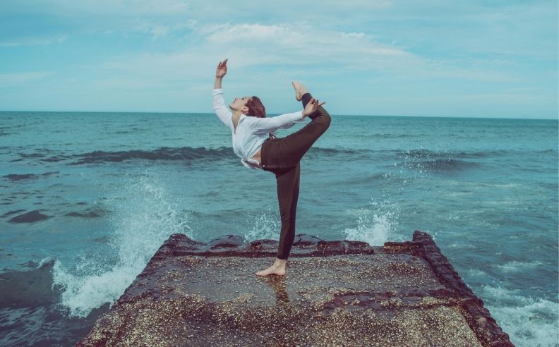 Femme qui fait du yoga sur une digue