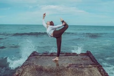 Femme qui fait du yoga sur une digue